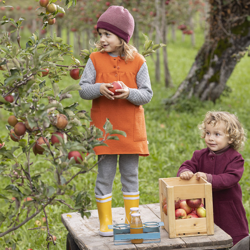 Disana boiled wool dress for girls—organic merino winter outfit layered with leggings and bonnet